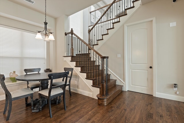 dining area featuring dark wood-type flooring and a notable chandelier