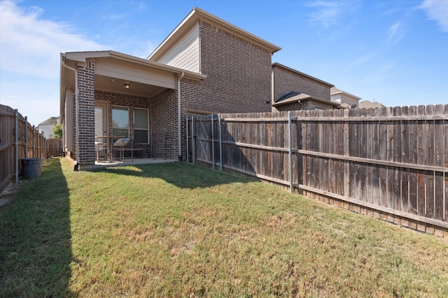 rear view of property with a patio area and a yard