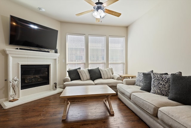 living room featuring dark wood-type flooring, a fireplace, and ceiling fan