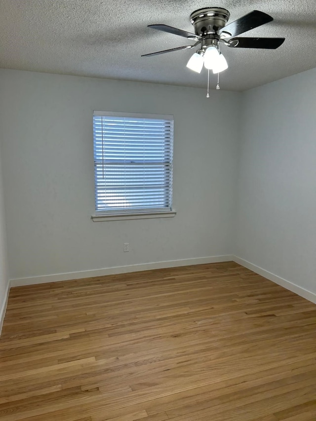 unfurnished room with a textured ceiling, light wood-type flooring, and ceiling fan