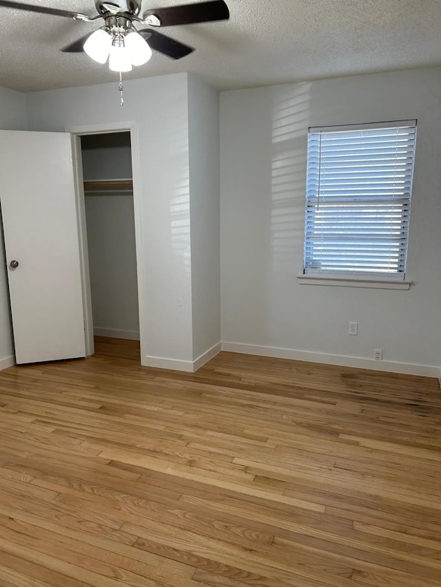 unfurnished bedroom with a closet, a textured ceiling, light wood-type flooring, and ceiling fan