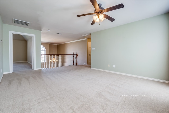 carpeted empty room featuring ornamental molding and ceiling fan with notable chandelier