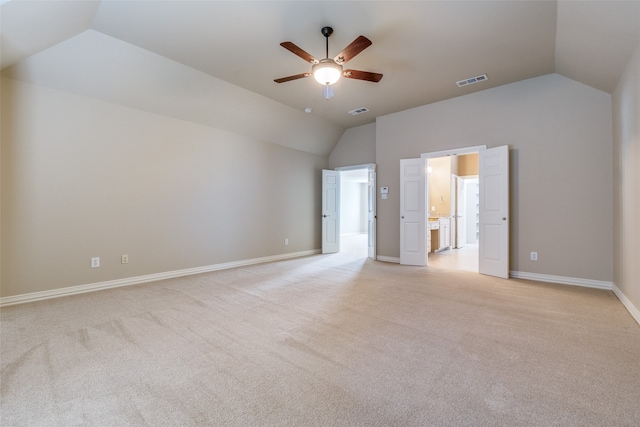 unfurnished bedroom featuring ceiling fan, vaulted ceiling, and light colored carpet