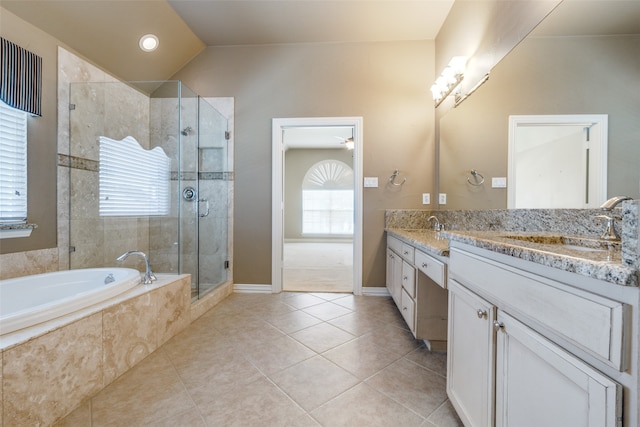 bathroom featuring vanity, independent shower and bath, vaulted ceiling, and tile patterned flooring