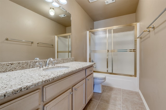 full bathroom with vanity, shower / bath combination with glass door, toilet, and tile patterned floors