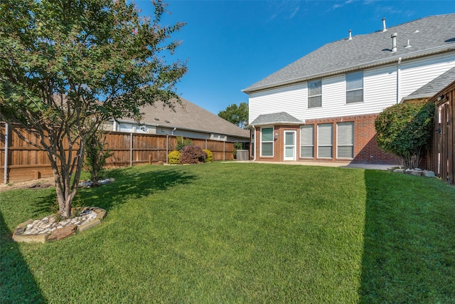 rear view of house with a patio, central air condition unit, and a lawn