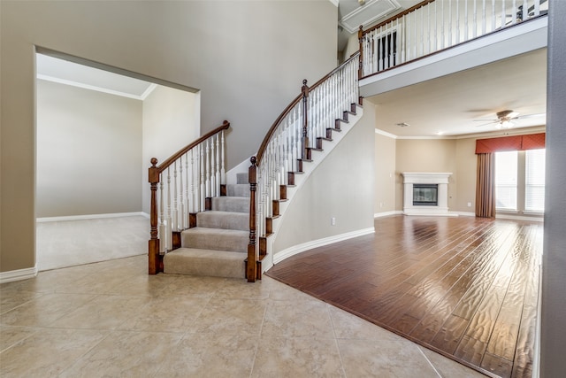 interior space featuring a towering ceiling, crown molding, and light wood-type flooring