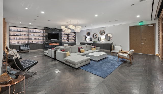 living room featuring built in shelves and dark parquet floors