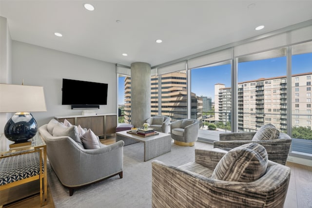 living area with plenty of natural light, recessed lighting, and a wall of windows