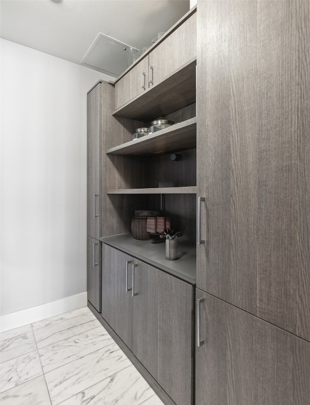 bar with baseboards and marble finish floor