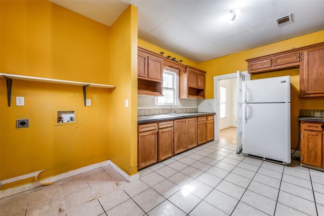 kitchen featuring white fridge, light tile patterned floors, and sink