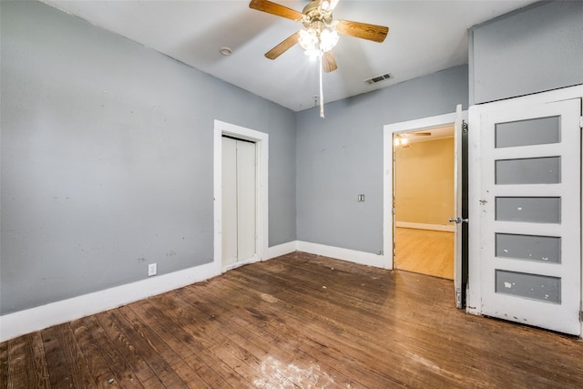 unfurnished bedroom featuring a closet, dark hardwood / wood-style floors, and ceiling fan