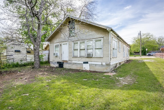 view of front facade with cooling unit and a front lawn