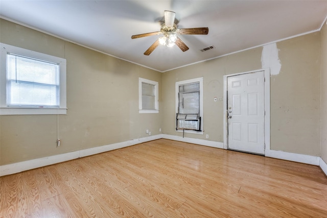 spare room featuring crown molding, light wood-type flooring, and ceiling fan