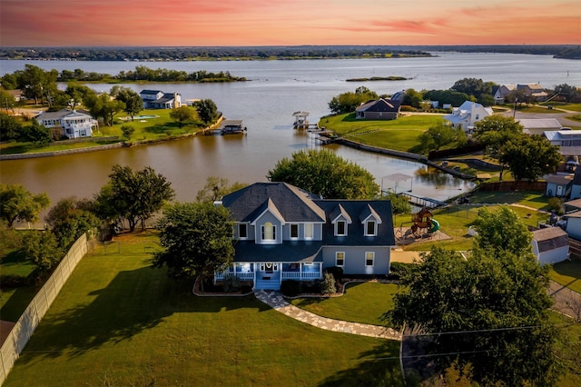 aerial view at dusk featuring a water view