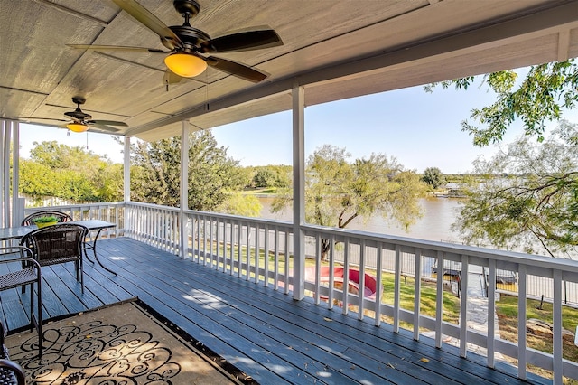 wooden deck with a water view and ceiling fan