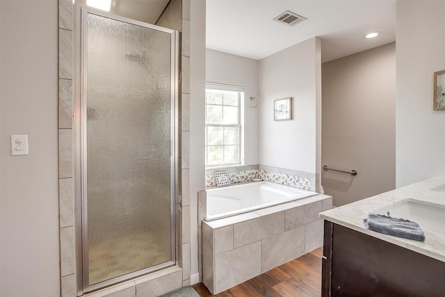 bathroom with vanity, hardwood / wood-style flooring, and shower with separate bathtub