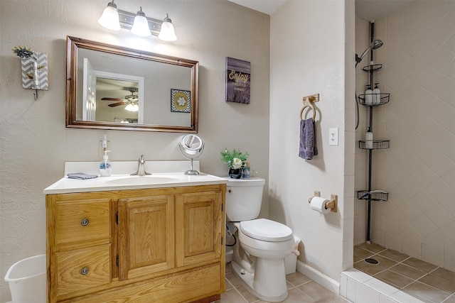 bathroom with vanity, toilet, tiled shower, and tile patterned flooring