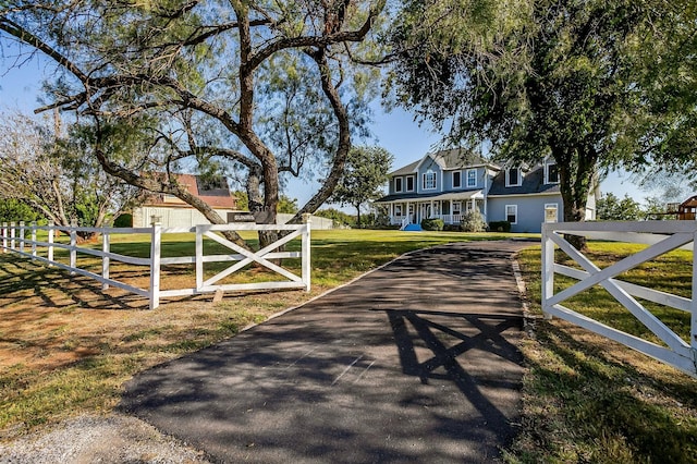 view of gate with a lawn