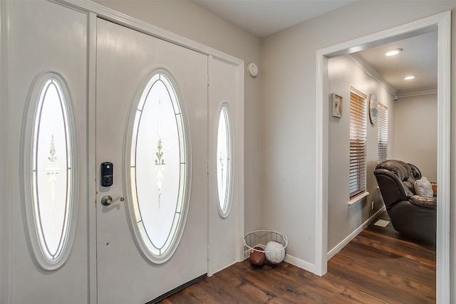 entrance foyer with dark wood-type flooring, crown molding, and a wealth of natural light