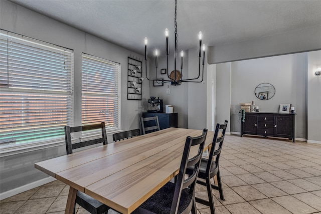 dining space featuring a textured ceiling, light tile patterned floors, and a notable chandelier