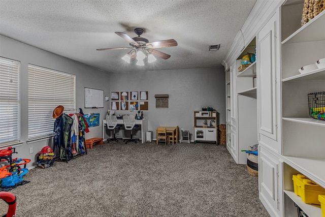 rec room featuring a textured ceiling, carpet flooring, and ceiling fan