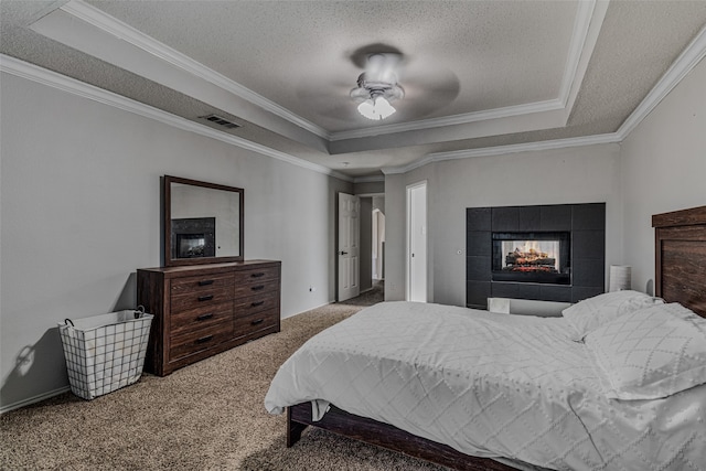 carpeted bedroom with ornamental molding, a textured ceiling, ceiling fan, and a raised ceiling