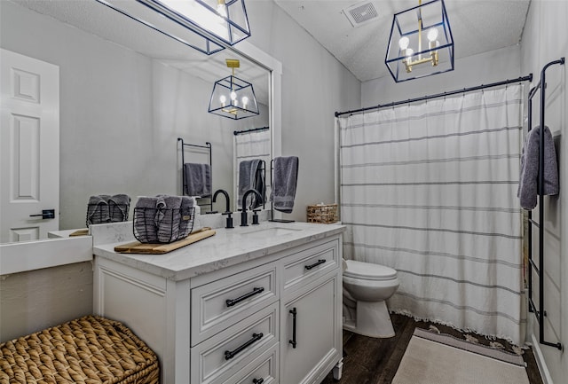 bathroom featuring hardwood / wood-style floors, a textured ceiling, toilet, and vanity