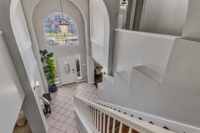 tiled foyer entrance featuring an inviting chandelier