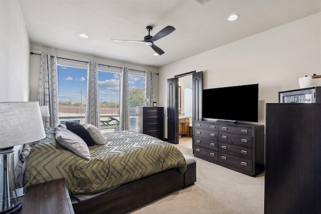 bedroom with light carpet, ensuite bath, and ceiling fan