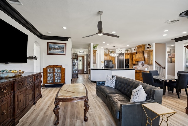 living room featuring ceiling fan, light hardwood / wood-style floors, and ornamental molding