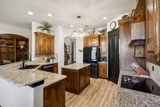 kitchen featuring black appliances, sink, decorative backsplash, light wood-type flooring, and kitchen peninsula