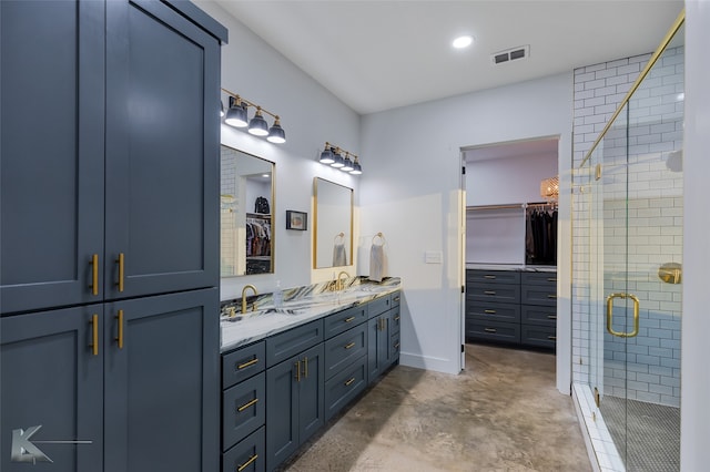 bathroom with vanity, a shower with shower door, and concrete flooring