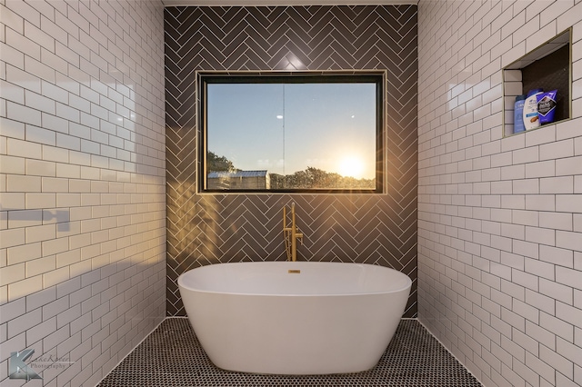 bathroom with tile walls and a tub