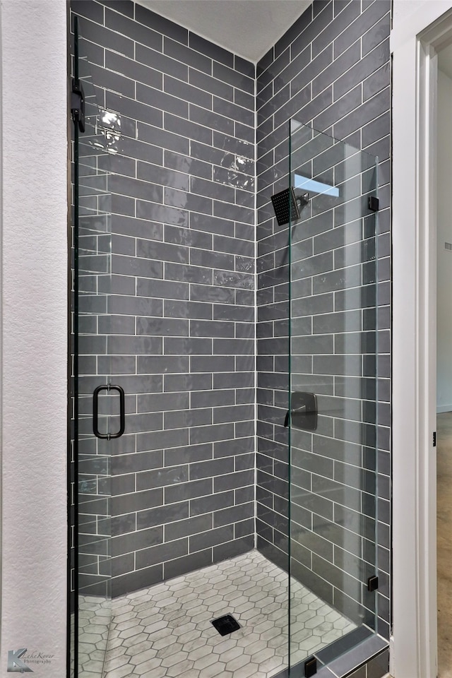 bathroom with a shower with door