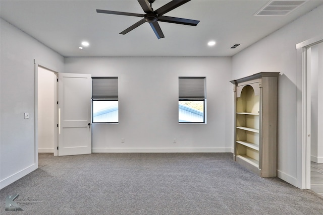 unfurnished bedroom featuring ceiling fan, carpet flooring, multiple windows, and a walk in closet