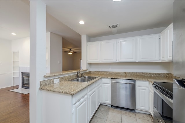 kitchen with light hardwood / wood-style flooring, stainless steel appliances, sink, and white cabinets