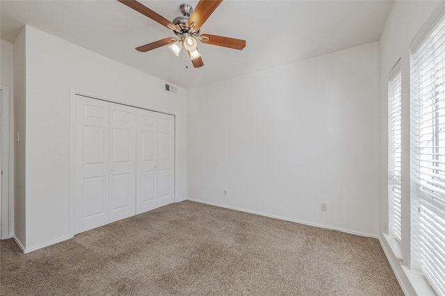 unfurnished bedroom with light carpet, a closet, and ceiling fan