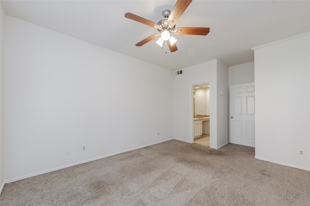 unfurnished bedroom featuring light colored carpet, ceiling fan, and ensuite bath