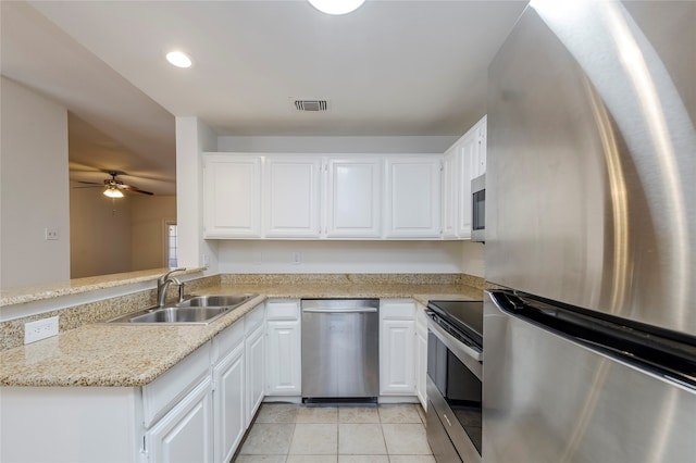 kitchen with light tile patterned flooring, white cabinets, stainless steel appliances, and sink