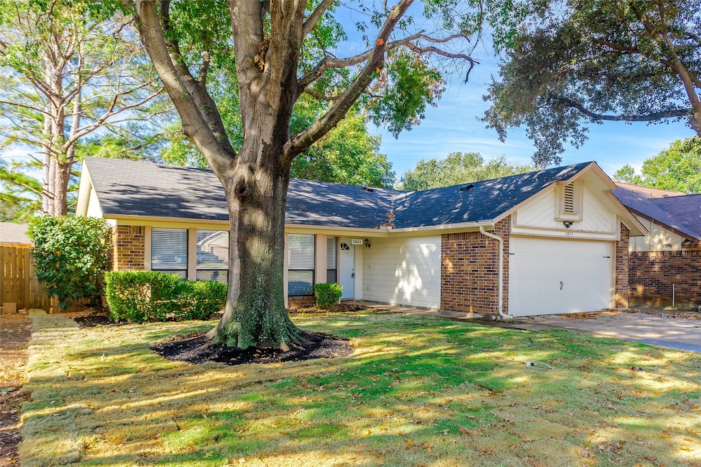 single story home featuring a garage and a front yard