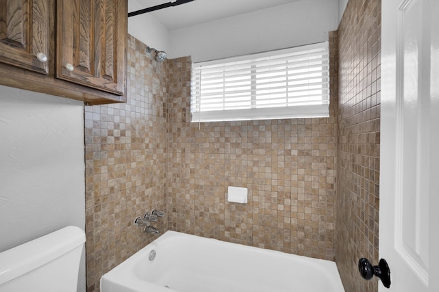 bathroom with tiled shower / bath and toilet