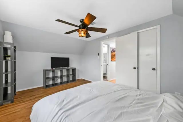 bedroom featuring lofted ceiling, light hardwood / wood-style flooring, a closet, and ceiling fan