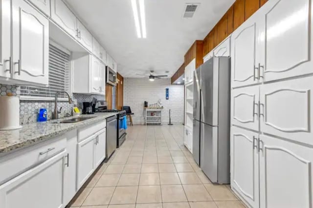 kitchen featuring white cabinets, stainless steel appliances, sink, and ceiling fan