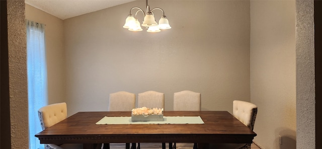 dining space featuring vaulted ceiling and an inviting chandelier