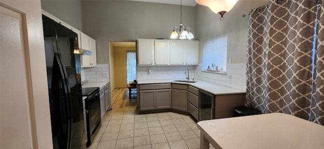 kitchen featuring hanging light fixtures, sink, black appliances, white cabinets, and tasteful backsplash