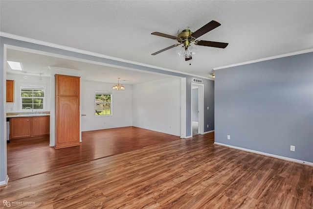 unfurnished living room featuring crown molding, a textured ceiling, ceiling fan with notable chandelier, and dark hardwood / wood-style flooring