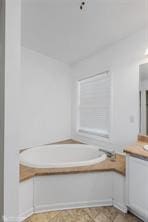 bathroom featuring vanity and a tub to relax in