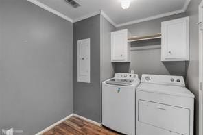 laundry area featuring cabinets, crown molding, separate washer and dryer, and dark hardwood / wood-style flooring