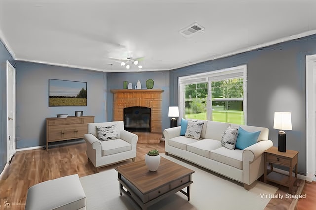 living room with hardwood / wood-style flooring, a fireplace, and ceiling fan